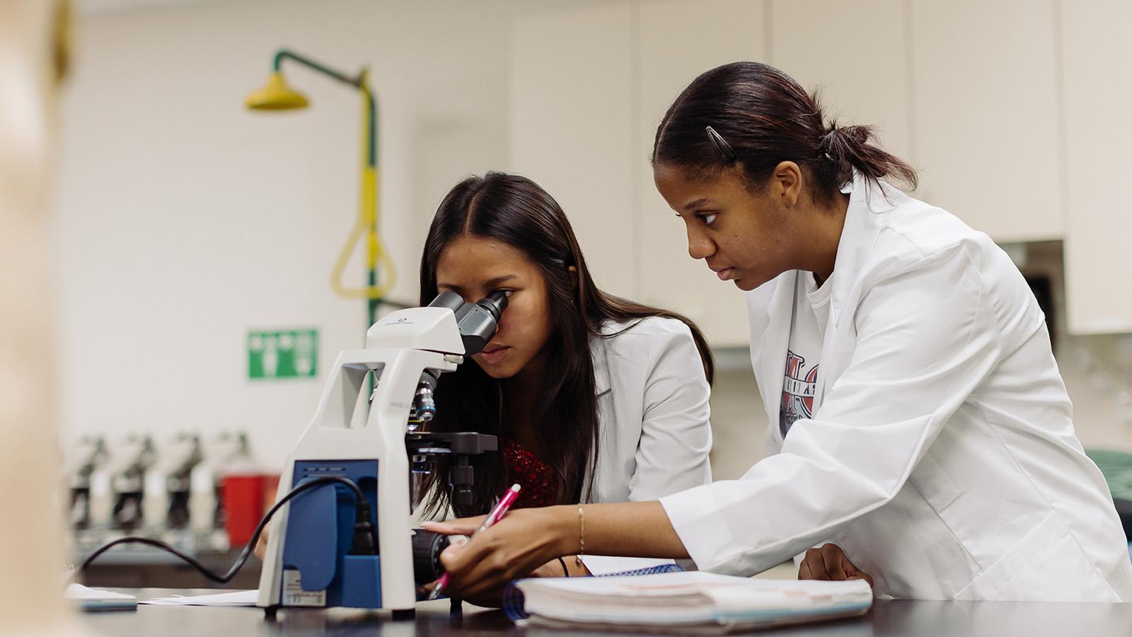 forensic science students looking through a microscope